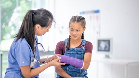 Une médecin évalue la douleur d'une jeune fille qui s'est blessé au bras.