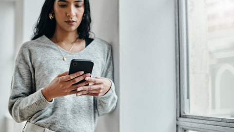 Une femme regarde son téléphone. Crédit photo: Delmaine Donson/Getty Images 