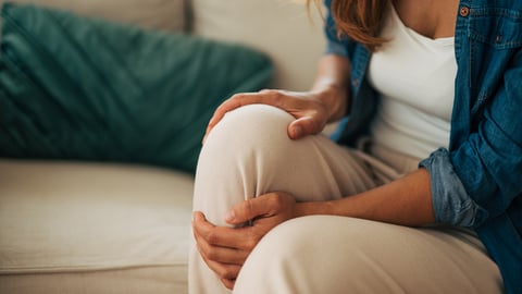 Une femme a de la douleur au genou.