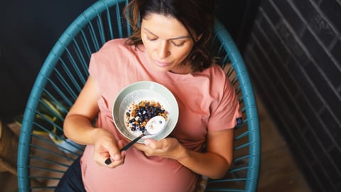 Une femme enceinte mange son repas santé.