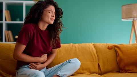 Une femme a d'intenses crampes au ventre, de la douleur abdominale.
