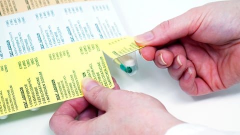 un pharmacien prépare des étiquettes de médicaments