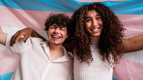 Deux jeunes personnes transgenres tenant un drapeau 