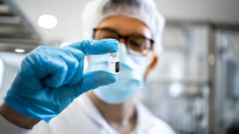 Un chercheur tient une fiole de médicament