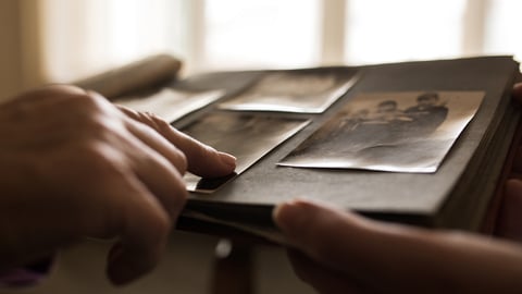 Une personne âgée partage ses vieilles photos et ses souvenirs avec une autre personne.