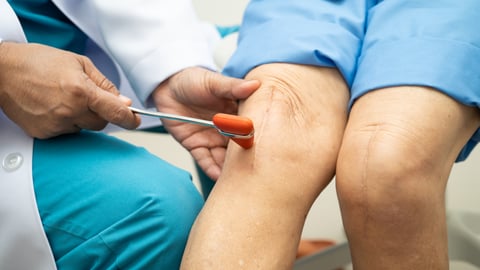 Medecin testant le genou avec un Marteau de Taylor