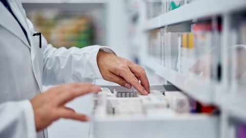 Les mains d'une pharmacienne en train de ranger des médicaments