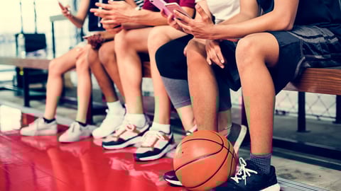 Group of young teenager friends on a basketball court relaxing using smartphone addiction concept; Shutterstock ID 1095984830