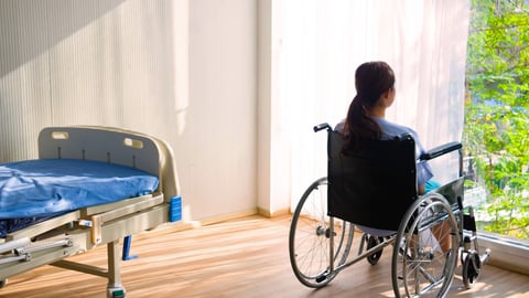 The woman sitting on wheelchair. She is see window with patient bed in hospital.disabled person lonely. Photo concept depression and Patient.; Shutterstock ID 1284347995