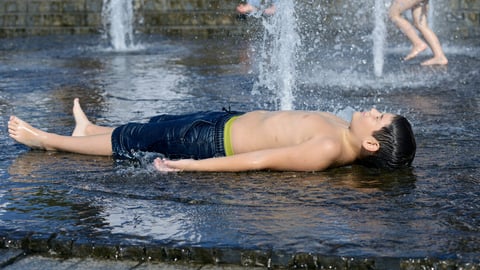 Strong heat in the city: little boy playing with fountain water jets at the square. June 5, 2019. Kiev, Ukraine; Shutterstock ID 1738153016