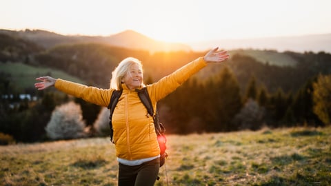 Front view of senior woman hiker standing outdoors in nature at sunset.; Shutterstock ID 1746068339