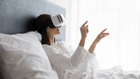 Amazed young woman sit wake up in white bed wearing virtual reality glasses, stunned millennial girl awaken rest in hotel or home bedroom try experience VR googles, modern technology concept; Shutterstock ID 1765350863