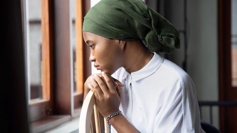 Portrait of sad African young woman cancer patient fighting with the sickness, wearing head scarf after suffering serious hair loss side effect due to chemotherapy, concept of cancer awareness; Shutterstock ID 1823686478