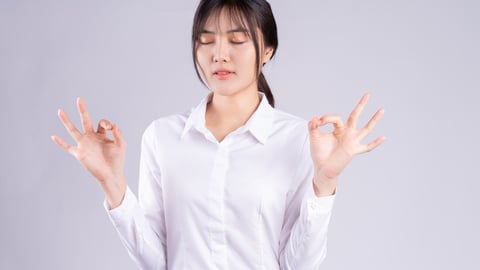 Young Asian woman taking deep breaths to stay calm