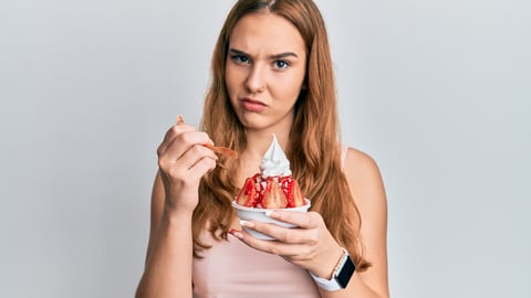 Young blonde woman eating strawberry ice cream skeptic and nervous, frowning upset because of problem. negative person. ; Shutterstock ID 2016656801