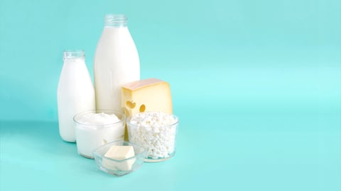 A postcard with milk products. Milk, kefir, sour cream, cheese, butter and cottage cheese in a glass container on a light background is a place for text.; Shutterstock ID 2124395006