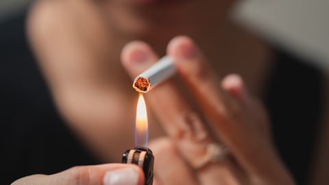 Smoker lighting a cigarette with lighter; Shutterstock ID 2384414661