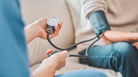 Nurse, elderly patient and blood pressure in house, retirement home and check up with medical professional. Monitor, hypertension and healthcare with pump for wellness, caregiver and people on sofa; Shutterstock ID 2494845927