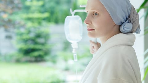 Young woman with skin cancer standing on a drip in hospital; Shutterstock ID 704925163