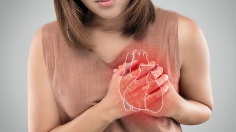 Représentation 3D d'un coeur sur une femme qui éprouve des douleurs cardiaques.