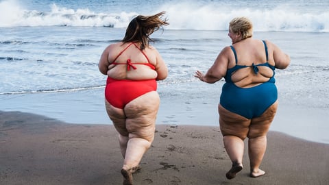 Deux femmes obèses courent sur la plage