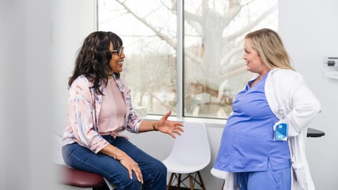 Une patiente discute avec sa gynécologue enceinte.