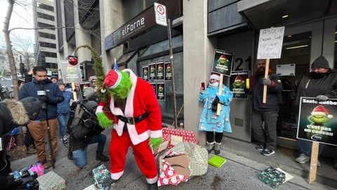 Lors d’une manifestation devant les bureaux de Santé Québec, l’APTS a mis en scène le Grinch qui est venu bousiller les souhaits du syndicat pour le réseau de la santé, qui étaient emballés dans des cadeaux de Noël. Crédit photo: PC/Katrine Desautels