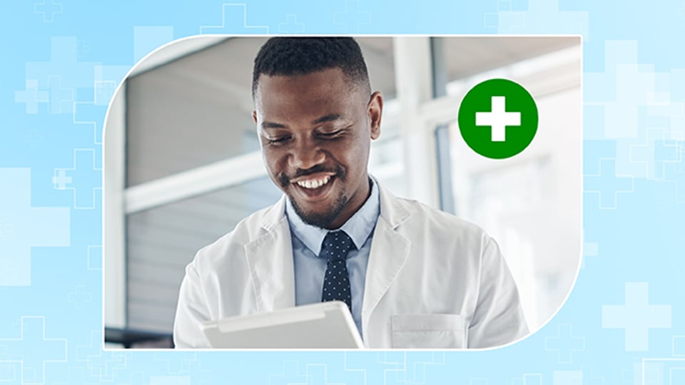 Médecin souriant en blouse blanche tenant une tablette.
