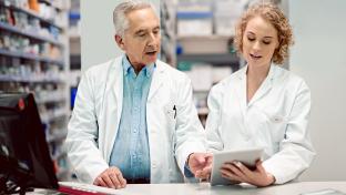 Deux pharmaciens collaborent derrière le comptoir d'une pharmacie.